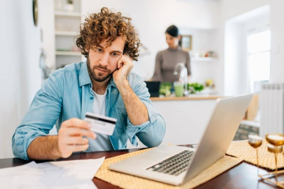 young-man-calculating-bills-pay-credit-in-front-of-laptop