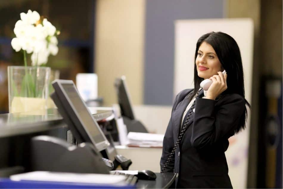 modern-luxury-hotel-woman-receptionist-holding-telephone