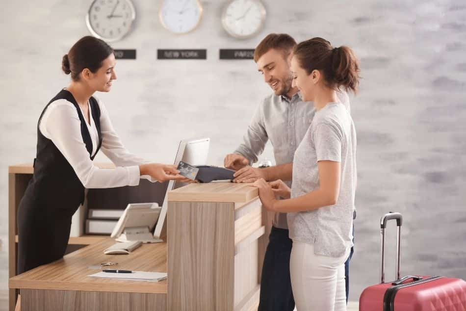 young-couple-paying-hotel-room-reception